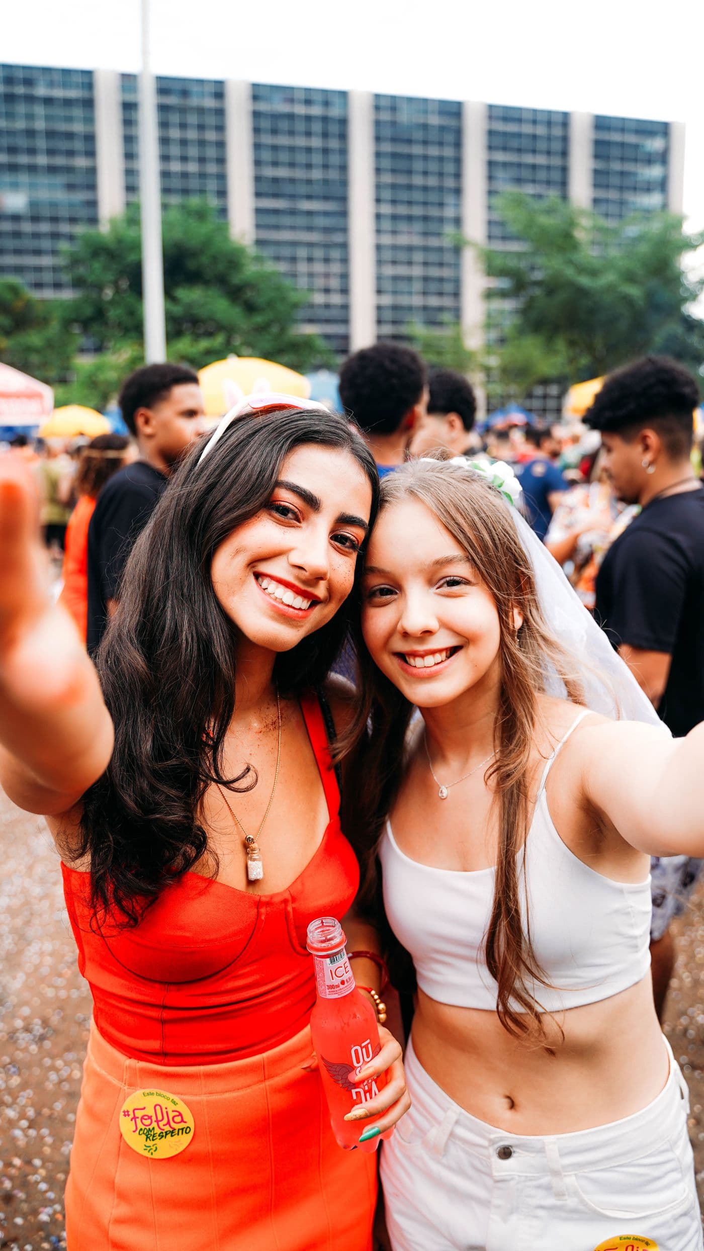 Two friends beaming together at a festival